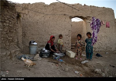 یک زن روستایی در حال شستوشوی ظروف است.روستای خمّر آخرین روستای ایران در منطقه هیرمند زابل