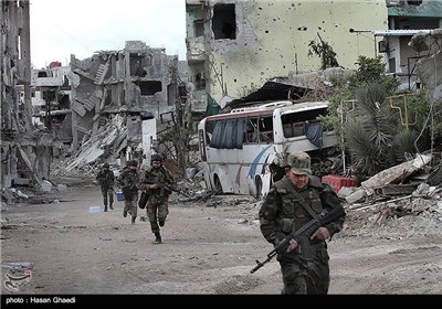 نیروهای ارتش سوریه برای گریز از تیررس تک تیراندازهای دشمن که در ساختمانهای مجاور مستقر شده اند، عرض یک خیابان را بسرعت طی میکنند./عملیات آزاد سازی حرم حضرت سکینه(س) در فروردین ماه 92