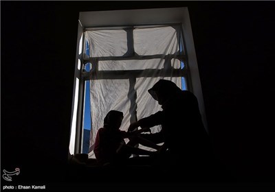 مادر رابعه در حال تعویض بانداژ زخم های دخترش است.