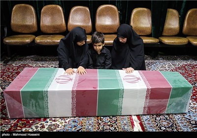 همسر ، فرزند و مادر شهید مدافع حرم علی اصغر شیردل در کنار پیکر وی