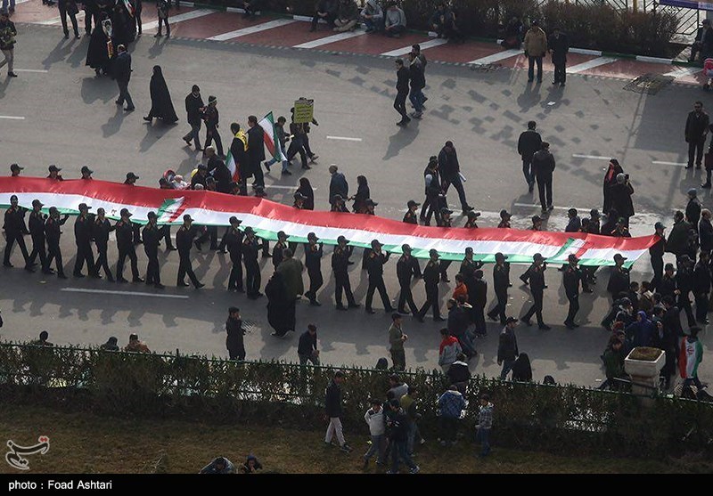 رفع أطول علم إیرانی فی مسیرات ذکرى الثورة +فیدیو