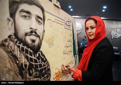 امضاء لوح یادبود اهدایی خانه سینما به خانواده شهید مدافع حرم محسن حججی توسط کمند امیرسلیمانی