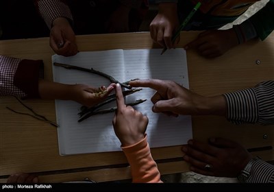 افشین تصوفی معلم مدرسه عشایری مصباح روستای سیه پشت، از شاخه درختان به عنوان وسایل کمک آموزشی در درس ریاضی به دانش آموزان استفاده میکند