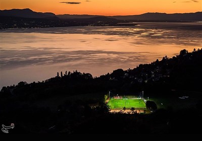 نمایی از یک ورزشگاه در غرب سوئیس و در کنار دریاچه جِنِوا که توسط پروژکتورها روشن شده است.