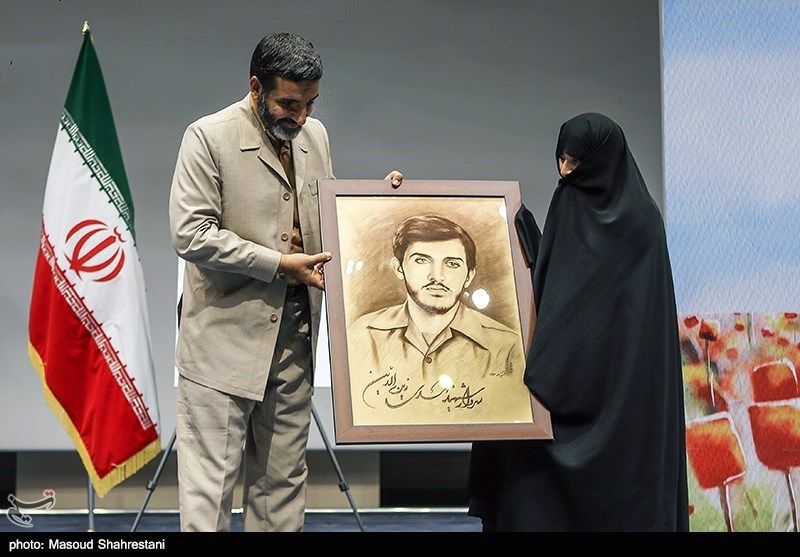 اهدای نقاشی شهید زین الدین به همسر شهید توسط حاج حسین یکتا در در مراسم رونمایی از کتاب(مربع های قرمز)
