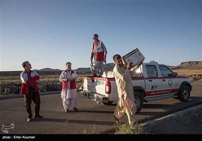 سازمان هلال احمر حین سرکشی به مناطق برای تحویل تانکرها بسته کمکی ارزاق به خانواده های نیازمند اهدا می کند.