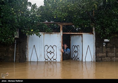 نیما عشوری 23 ساله ساکن روستای میان پشته رودسر سعی میکند در ورودی خانه را باز کند تا شاید کمی از ارتفاع آبی که داخل خانه نفوذ کرده کاسته شود.