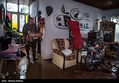 سید جواد حسینی 47 ساله ساکن روستای میان پشته رودسر وسایل خانه اش را که به زیر آب رفته جابجا میکند.