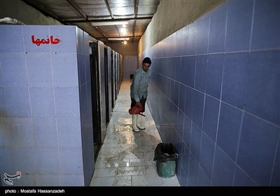 اکبر پور علی در حال نظافت سرویس های بهداشتی امامزاده محمد حسن(ع)