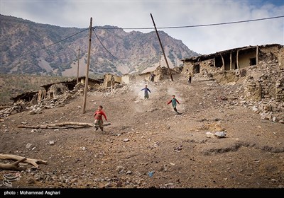 روستای دست گرد-بخش ذلقی شرقی- شهرستان الیگودرز-استان لرستان-کودکان برای بازی در محیط بازیشان از سرازیری خانه های متروک به پایین جاده می آیند.