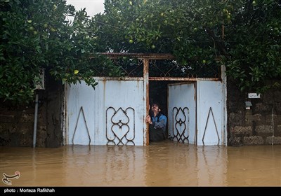 نیما عشوری 23 ساله، سعی میکند در ورودی خانه را باز کند تا شاید کمی از ارتفاع آبی که داخل خانه نفوذ کرده کاسته شود. روستای میان پشته رودسر 14 مهر 97