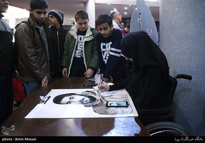 یکی از حضار این مراسم که از معلولیت جسمی نیز برخوردار بود عکس شهید ابراهیم هادی را طراحی میکرد