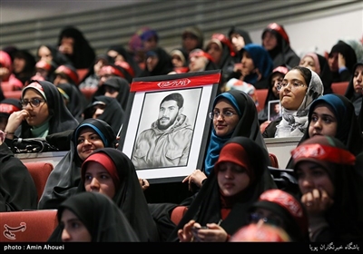 جمعی از جوانان و عاشقان شهدا در مراسم یادواره شهید ابراهیم هادی تابلوی نقاشی شده شهید را روی دست گرفتند