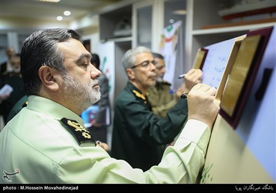 نوشتن یادبود سردار حسین اشتری فرمانده نیروی انتظامی در مراسم رونمایی ازکارت ایثار رزمندگان