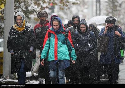 پیاده‌روی شهروندان تهرانی در خیابان ولیعصر در روز برفی پایتخت به دلیل عدم تأمین وسایل نقلیه عمومی