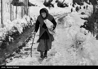 آقا مادر حیدری 70 ساله برای تهیه آذوقه به سمت بازاری که خارج از روستا قرار دارد حرکت میکند. او میگوید پس از ریزش بهمن قسمتی از سقف خانه اش تخریب شده و همچنین تمام راه های ارتباطی با روستا قطع شده،ُ آنها پس از گذشت 5 روز موفق به باز کردن مسیر شده اند.