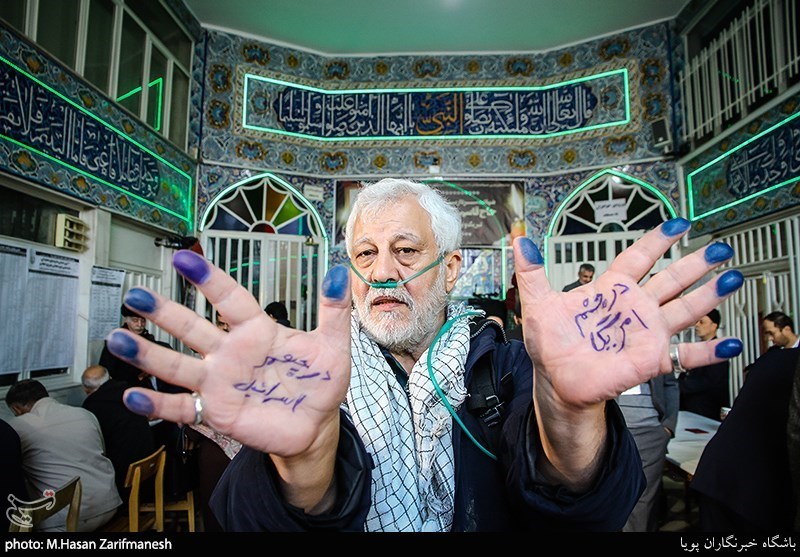 An elderly man poses after voting in the Narmak neighborhood of Tehran 