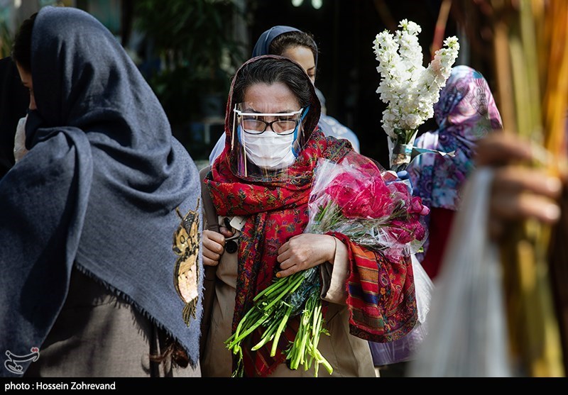 A woman shopped for flowers wearing a face mask and plastic visor on March 18.