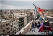 آقای تاجیک برای سرگرم کردن کودکان خود در روز سیزده به در برای آن ها بر بالای پشت بام چادر زده و در حال بالا بردن بادبادک است.