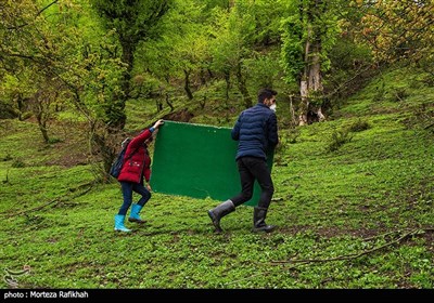 مبین شریفی و مهدی تخته سیاه مدرسه را به سمت محل برگزای کلاس در فضای باز انتقال میدهند