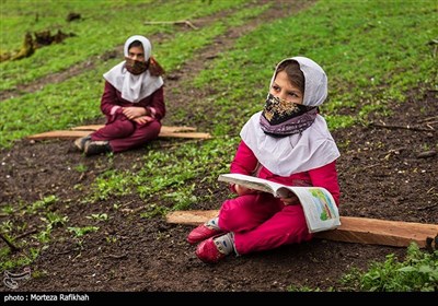 الینا و زیبا درکلاسی درسی که به علت شیوع ویروس کرونا در فضای باز برگزار شده به مطالب آموزشی معلم گوش میدهند