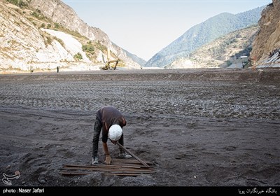 کارگری درحال جابه جایی مصالح در محل احداث سد هراز