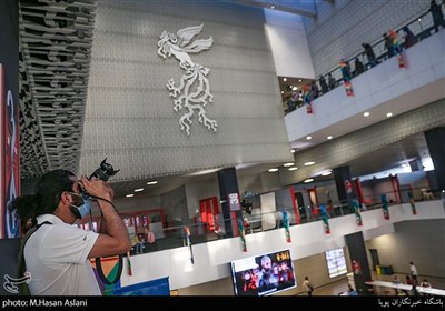 هادی زند عکاس خبرگزاری ایسنا در حال ثبت گزارش با رعایت پروتکل های بهداشتی در دومین روز سی‌وهشتمین جشنواره جهانی فیلم فجر در پردیس سینمایی چارسو
