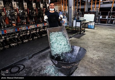 کارگر بطری های شکسته شده را به درون محفظه میریزد تا دوباره به درون کوره برود و فرایند تولید شیشه از اول آغاز شود.