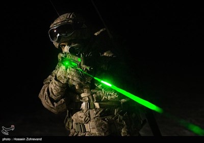 یکی از نیروهای تیپ ویژه صابرین در حال تمرین تیراندازی شبانه است