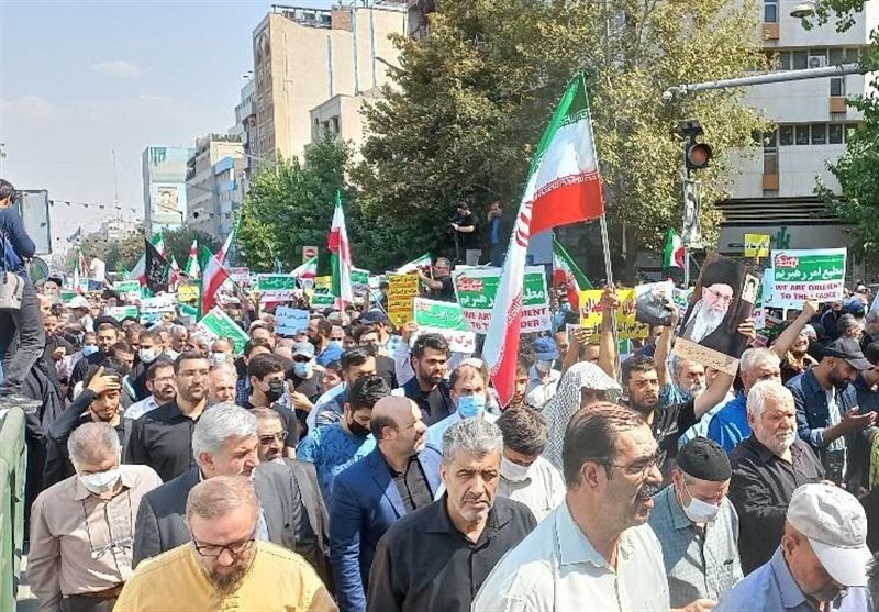 پرچم سه‌رنگ جمهوری اسلامی ایران در دست راهپیمایان تهرانی