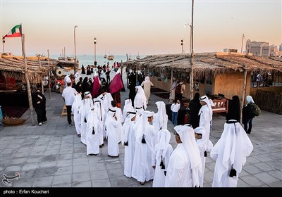 کودکان با لباس های عربی در ساحل منطقه فرهنگی کاتارا ایستاده اند.