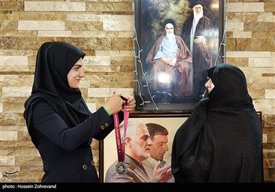 سپیده بابایی مدال نقره رقابت‌های کشتی آلیش آسیا خود را بر گردن همسر شهید طهرانی مقدم می اندازد 