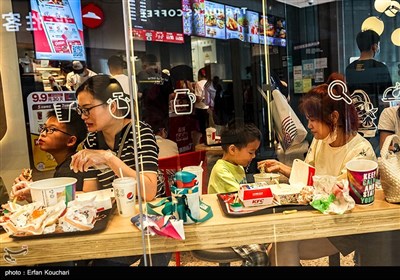 دو مادر به کوکان خود غذا میدهند. به علت سیاست های جمعیتی دولت چین عموم مردم تنها میتوانند یک فرزند داشته باشند.