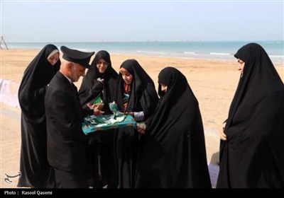 اهتزاز پرچم حرم رضوی در سواحل خلیج فارس بوشهر