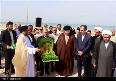 اهتزاز پرچم حرم رضوی در سواحل خلیج فارس بوشهر
