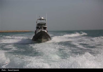 اهتزاز پرچم حرم رضوی به دست خدام در سواحل خلیج فارس بوشهر