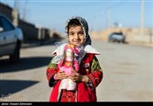 یک دختر بچه در حالی که یک عروسک در دست دارد در روستای مرزی ملکی در خراسان جنوبی